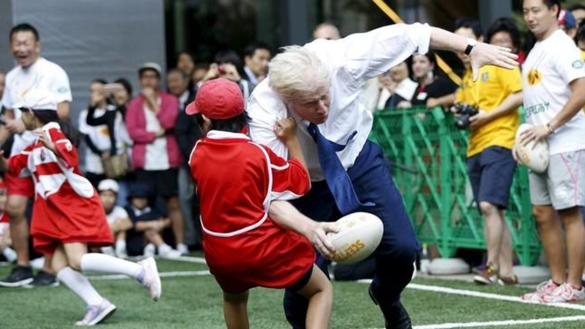 Boris Johnson colisiona contra un crío de 10 años en Tokio.-