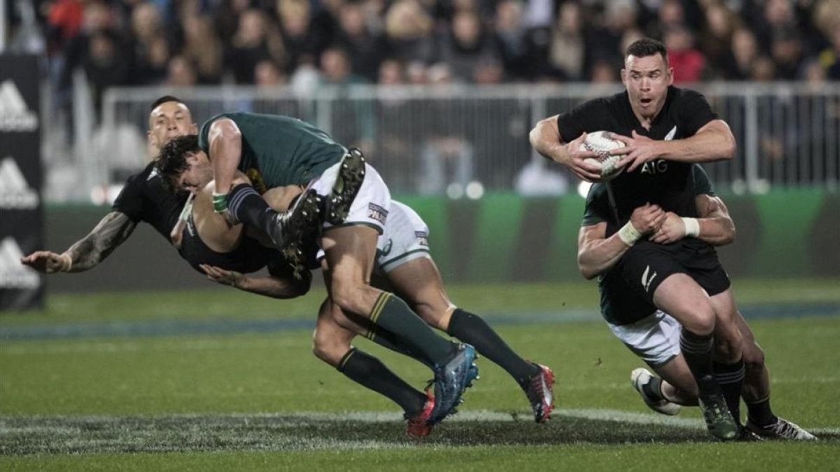 El neozelandés Ryan Crotty trata de avanzar durante el partido contra Sudáfrica-AP / BRETT PHIBBS
