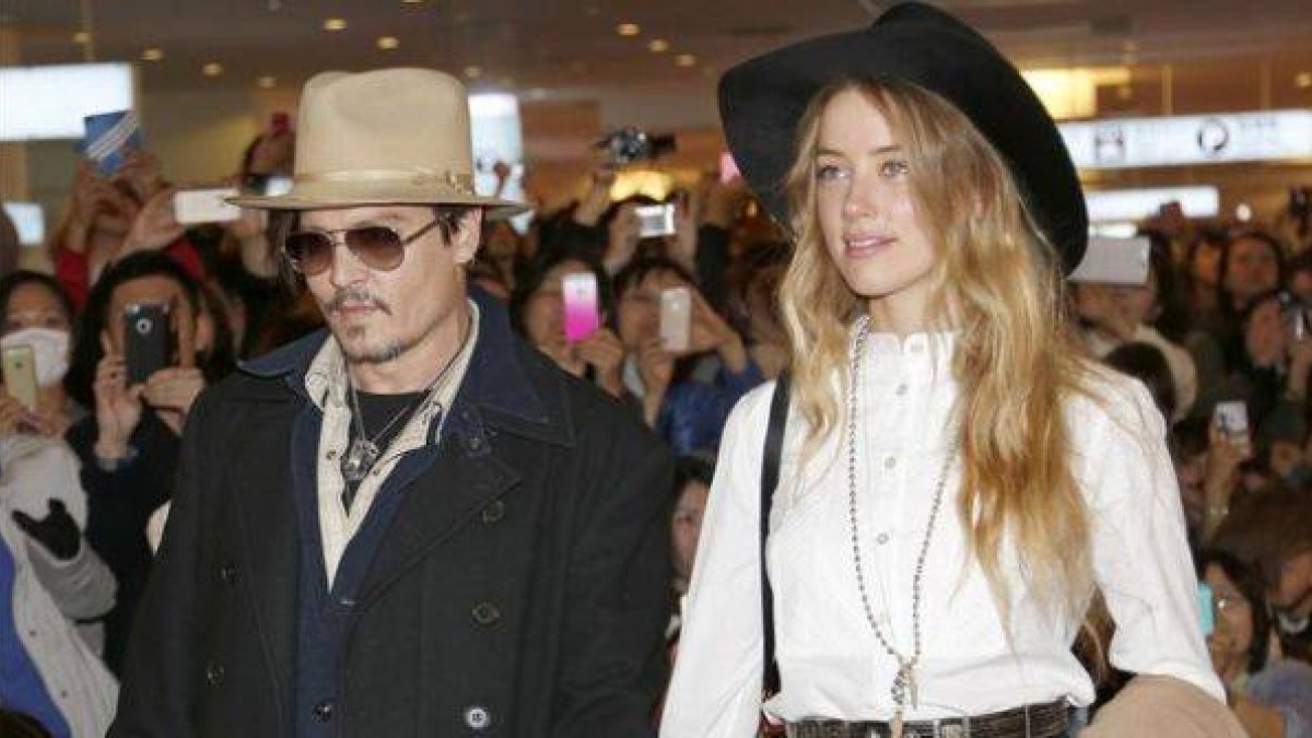 Johnny Depp y su novia, Amber Heard, este jueves en Tokio, a donde el actor ha viajado desde Australia para promocionar su última película, 'Mortdecai'.-Foto: AP / SHIZUO KAMBAYASHI