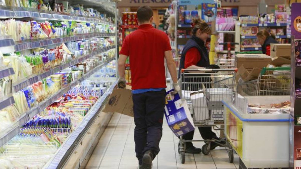 Un empleado repone género en un expositor refrigerado de lácteos, uno de los artículos de mayor consumo en la cesta de la compra, en la que la marca burgalesa Campofrío es una de las más consumidas.-RAÚL OCHOA