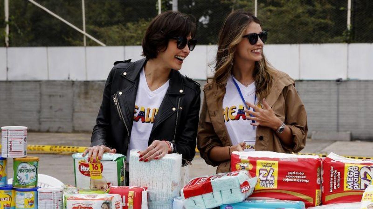 Dayana Mendoza y Stefania Fernandez reciben donaciones durante el evento Healing Venezuela.-EFE