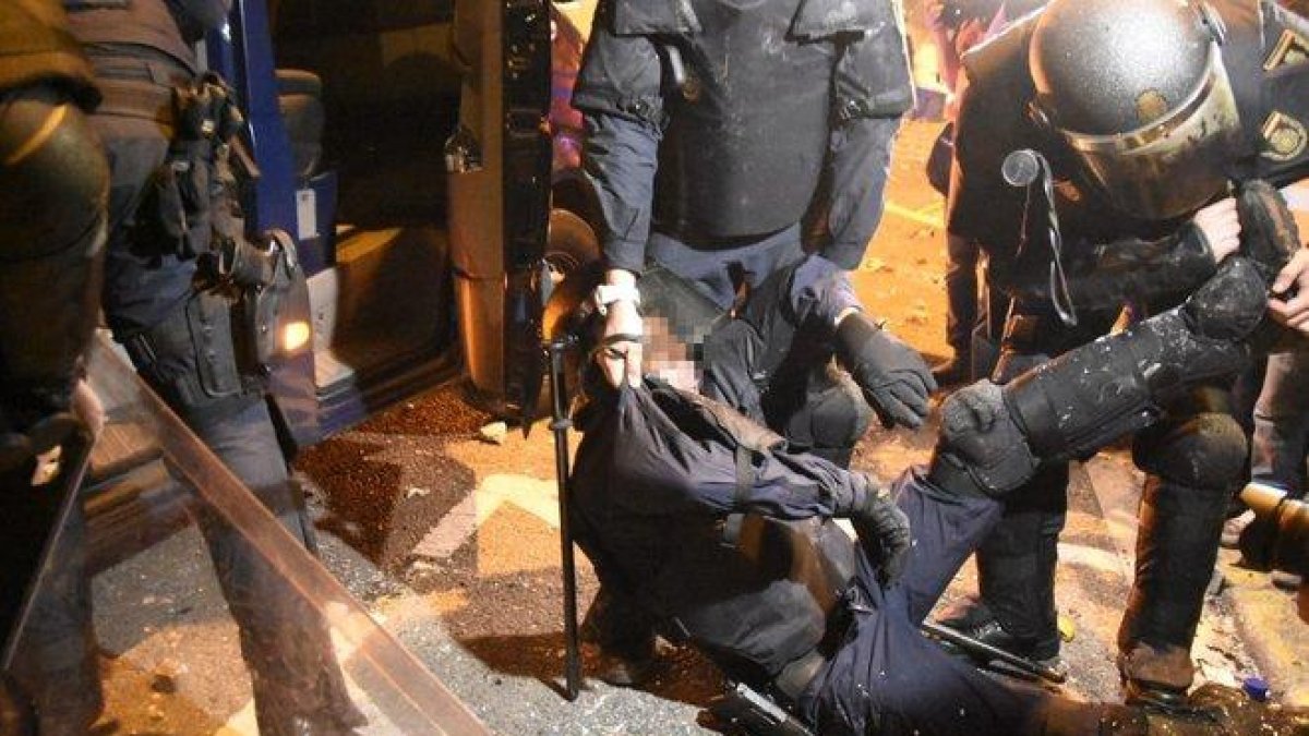 Un policía, cargado por sus compañeros tras ser herido en los enfrentamientos con los manifestantes en Via Laietana, este viernes.-MANU MITRU
