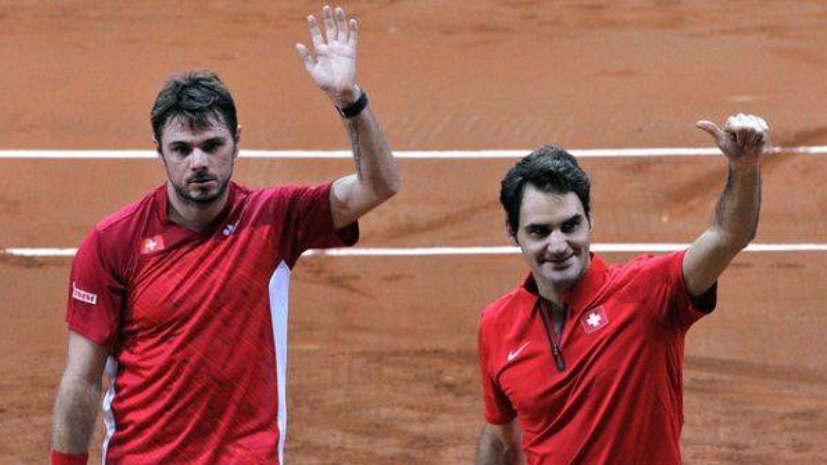 Stanislas Wawrinka y Roger Federer saludan al público tras ganar el partido de dobles de la Copa Davis.-Foto: AFP / FRANCOIS LO PRESTI