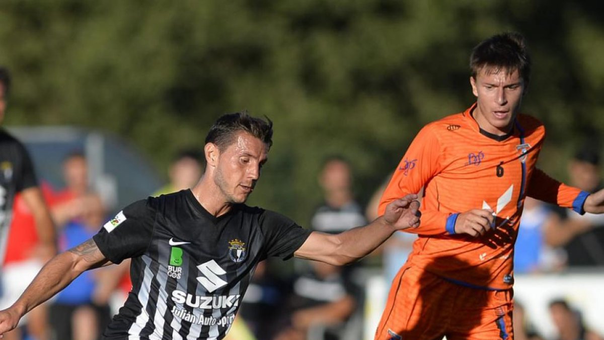 Adrián Cruz controla el balón ante Juan, jugador del BP CajaRural, en un lance del partido de ayer.-RICARDO ORDÓÑEZ