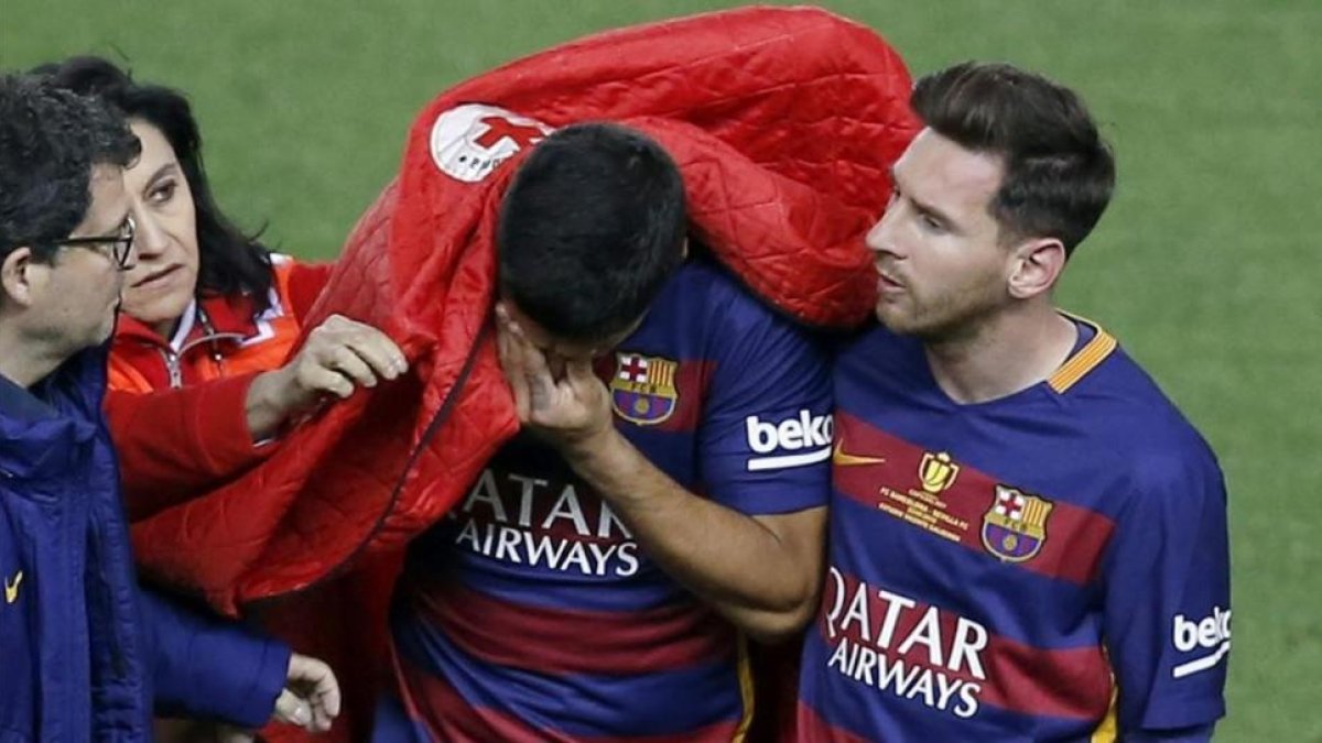 Messi consuela a Luis Suárez en el Calderón tras la lesión muscular que padeció el uruguayo.-EFE / CHEMA MOYA