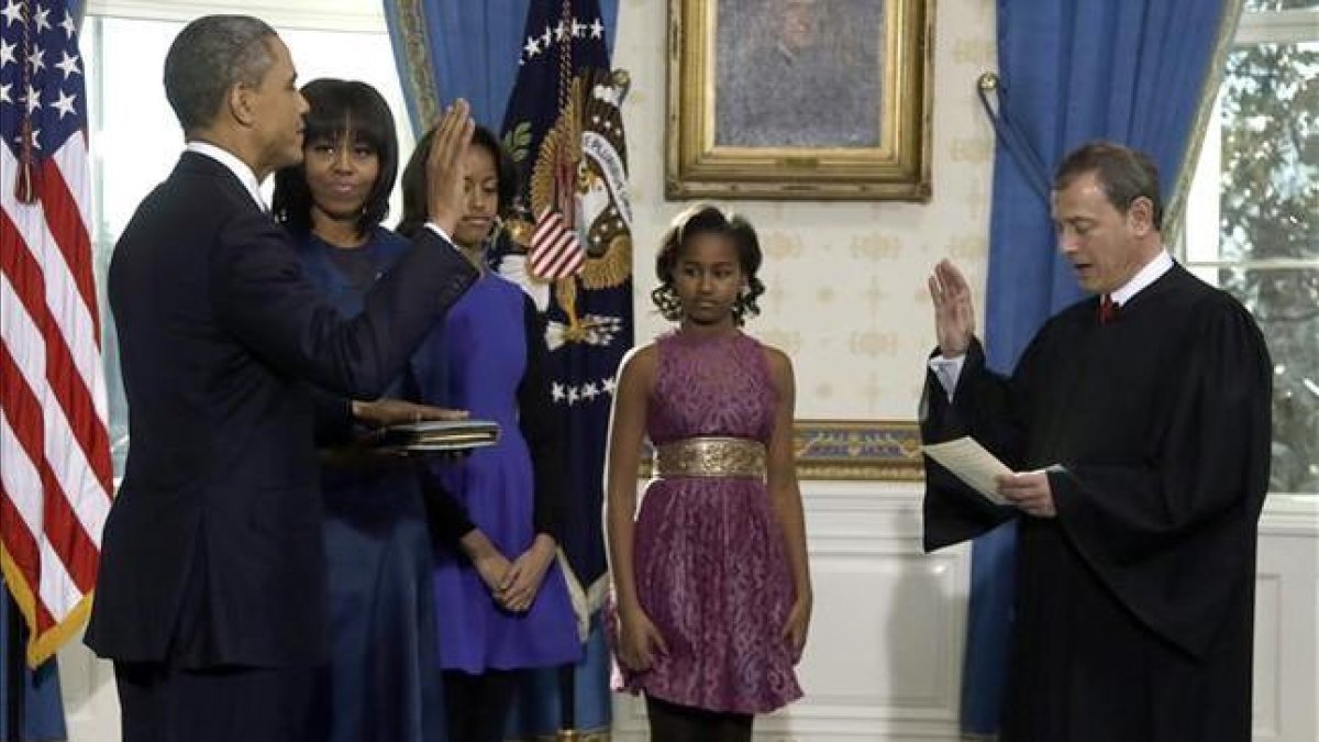La esposa y las hijas de Obama presencian la jura de este ante John Roberts, presidente del Tribunal Supremo, este domingo en la Casa Blanca.-AP