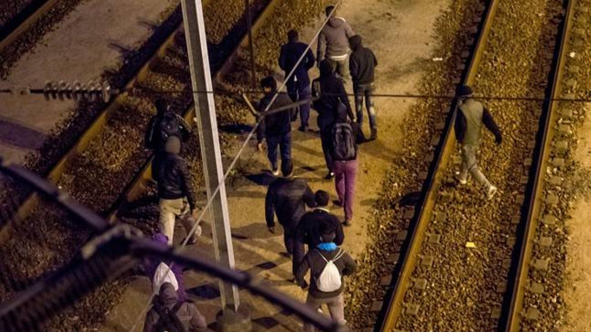 Un grupo de inmigrantes camina por las vías del Eurotunnel, este martes.-Foto: AFP / PHILIPPE HUGUEN