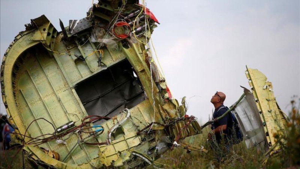 Un investigador inspecciona los restos del avión malasio siniestrado.-MAXIM ZMEYEV (REUTERS)