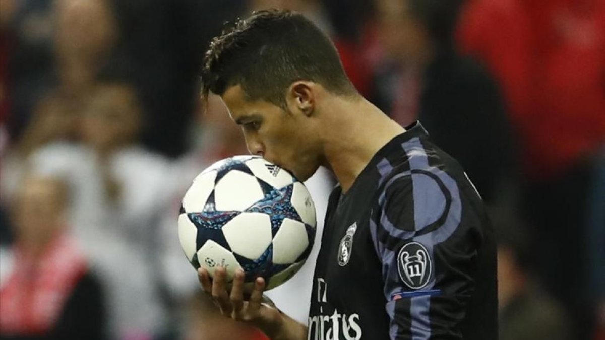 Cristiano Ronaldo besa el balón antes de lanzar una falta.-AFP / ODD ANDERSEN