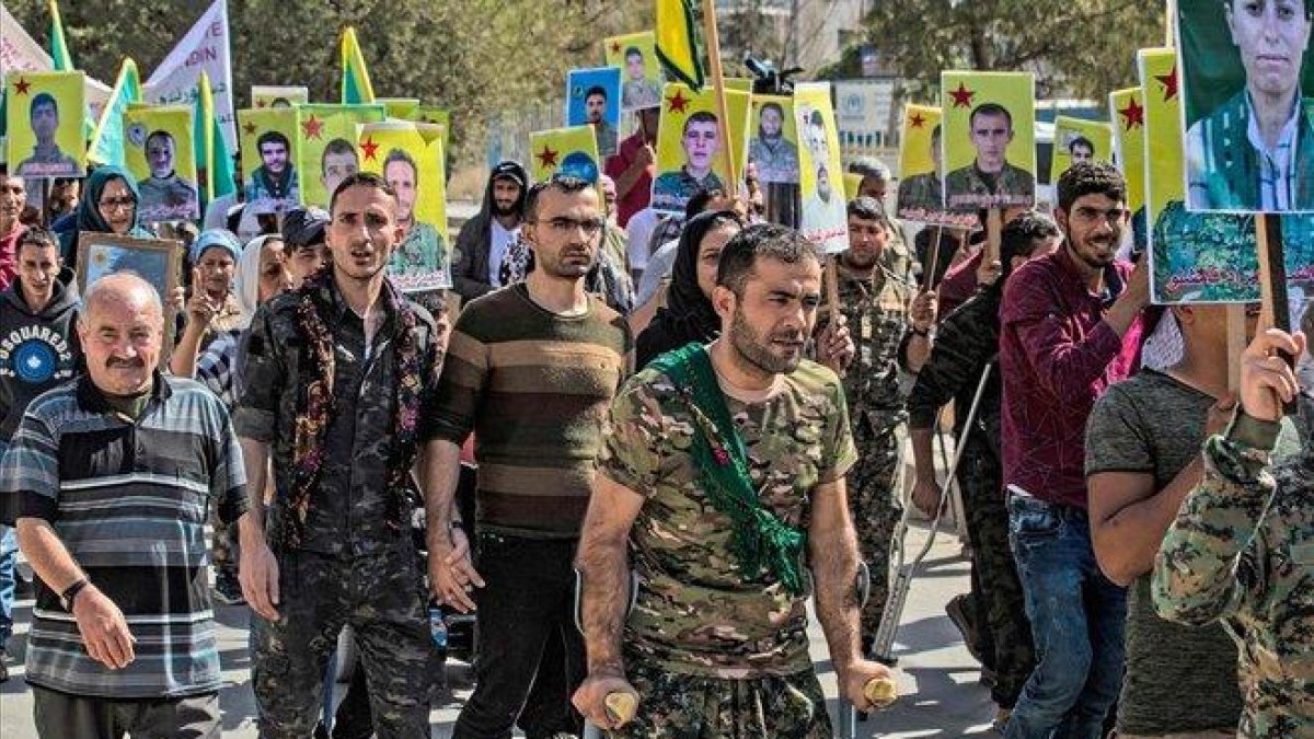 Milicianos y veteranos kurdos protestan frente a la sede de la ONU en la ciudad de Qamishli, en el norte de Siria.-DELIL SOULEIMAN (AFP)