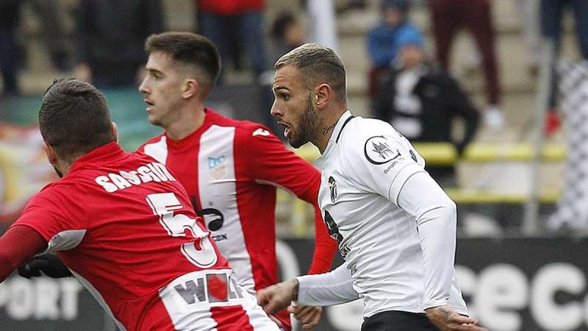 Elliot acosado por dos contrarios en el choque ante el Navalcarnero.-SANTI OTERO