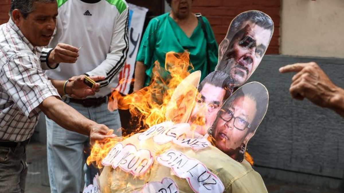 La quema de un muñeco con la foto de Nicolas Maduro y otros políticos de su gobierno.-EFE
