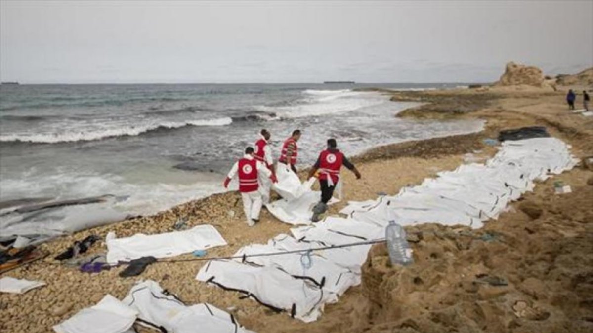 Decenas de cuerpos sin vida de inmigrantes alineados en una playa de Zawiya, ayer.-AFP / AMIN ELAMR