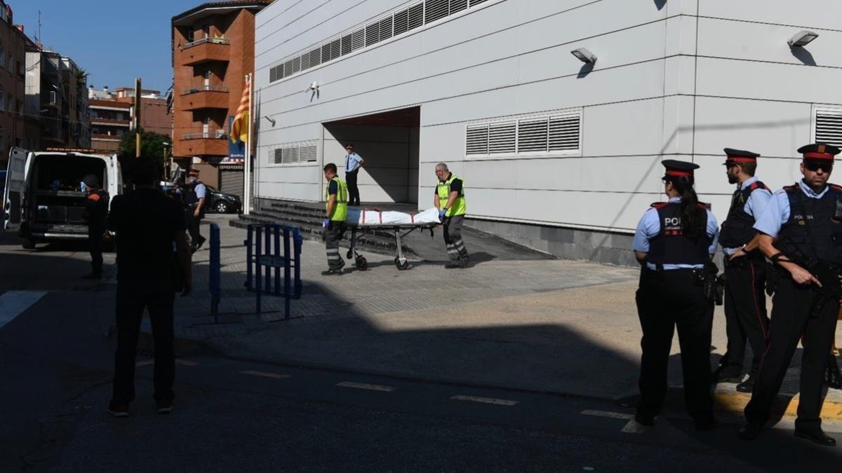 Miembros de la funeraria judicial retiran el cadáver del agresor de la comisaría de los Mossos en Cornellà-JORDI COTRINA