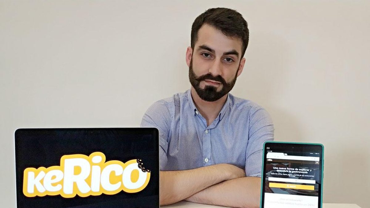 El burgalés Jairo González posa con un ordenador y una tableta donde se puede ver su aplicación gastronómica.-ECB