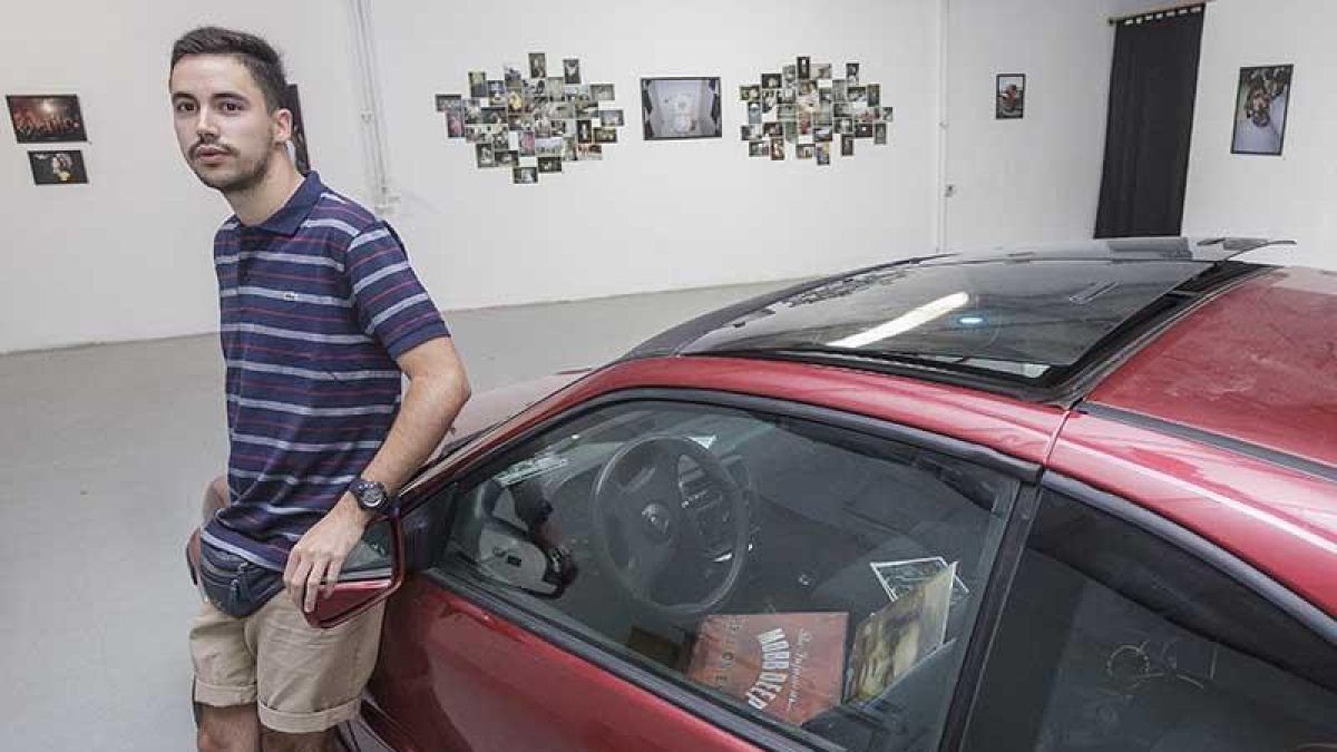Jaime Uvedoble, junto al coche que ocupa el centro de la sala que acentúa el carácter urbano de la colección que viste las paredes.-Santi Otero