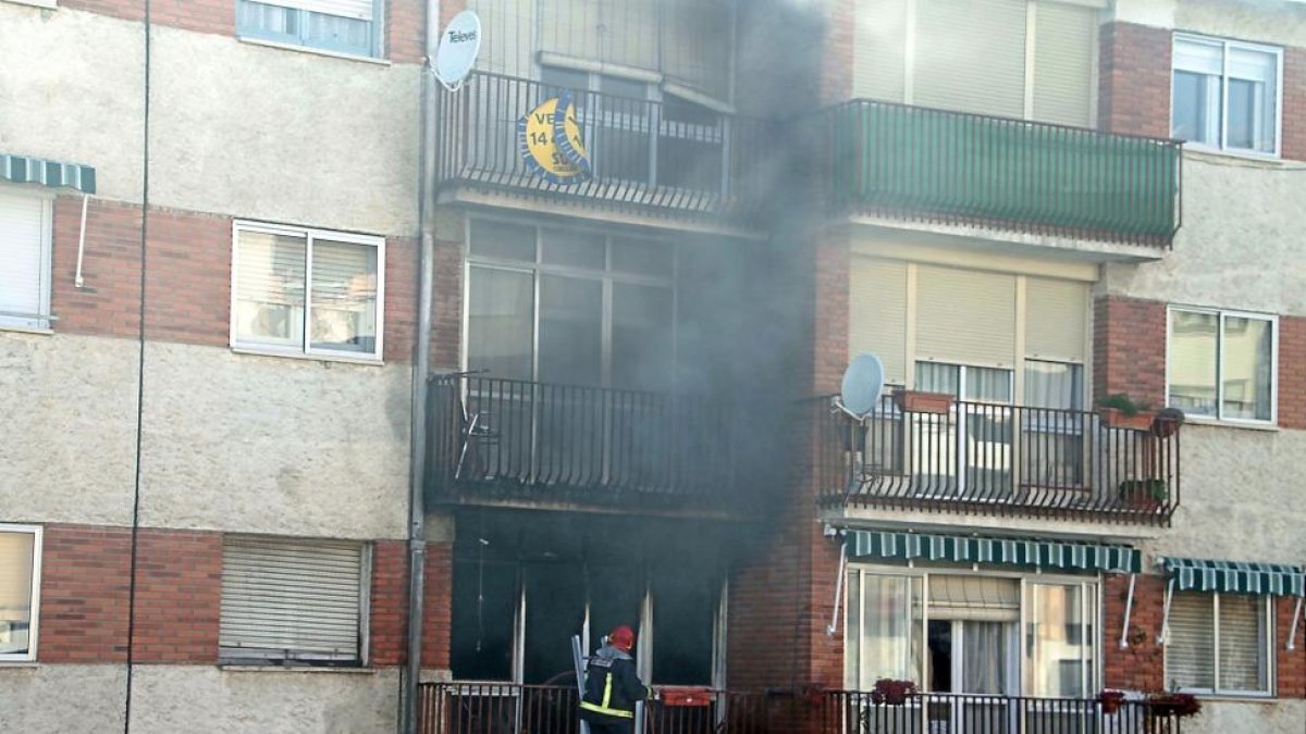 Un bombero interviene en la vivienda siniestrada en Cuéllar.-ICAL