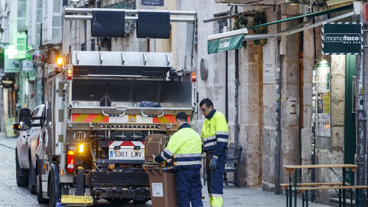 Dos operarios recogen el cubo de residuo orgánico de un establecimiento. SANTI OTERO
