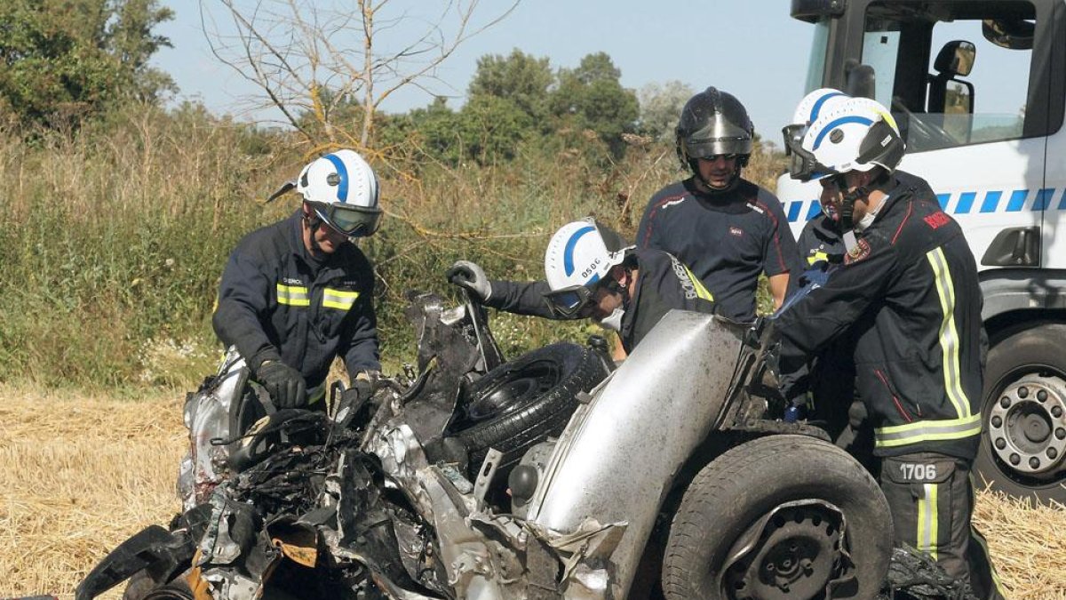 Los bomberos de Burgos trabajan en el vehículo en el que viajaban los vehículos.-G. GONZÁLEZ