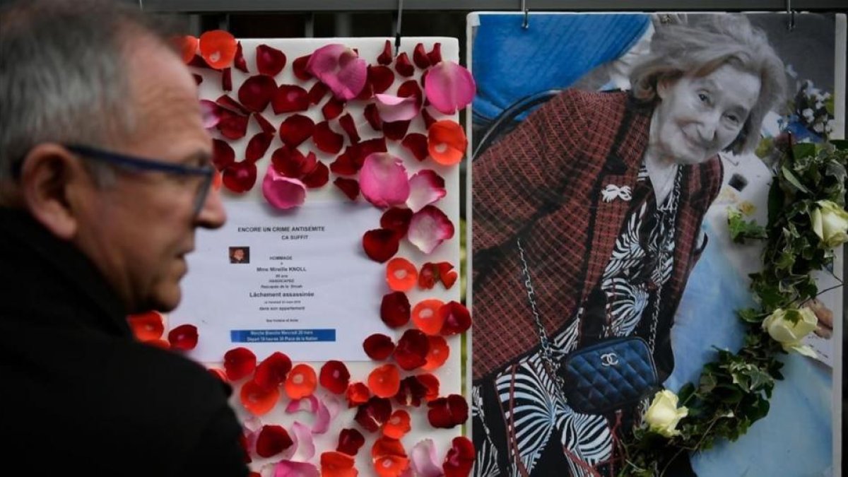 Una hombre mira una foto de Knoll y la convocatoria a una marcha de protesta por su asesinato, en París.-/ LIONEL BONAVENTURE