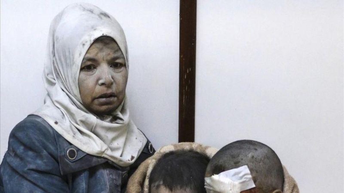 Una mujer abraza a sus hijos tras resultar todos heridos en un bombardeo en el barrio de Al Barze.-SARIEH ABU ZAID / EFE