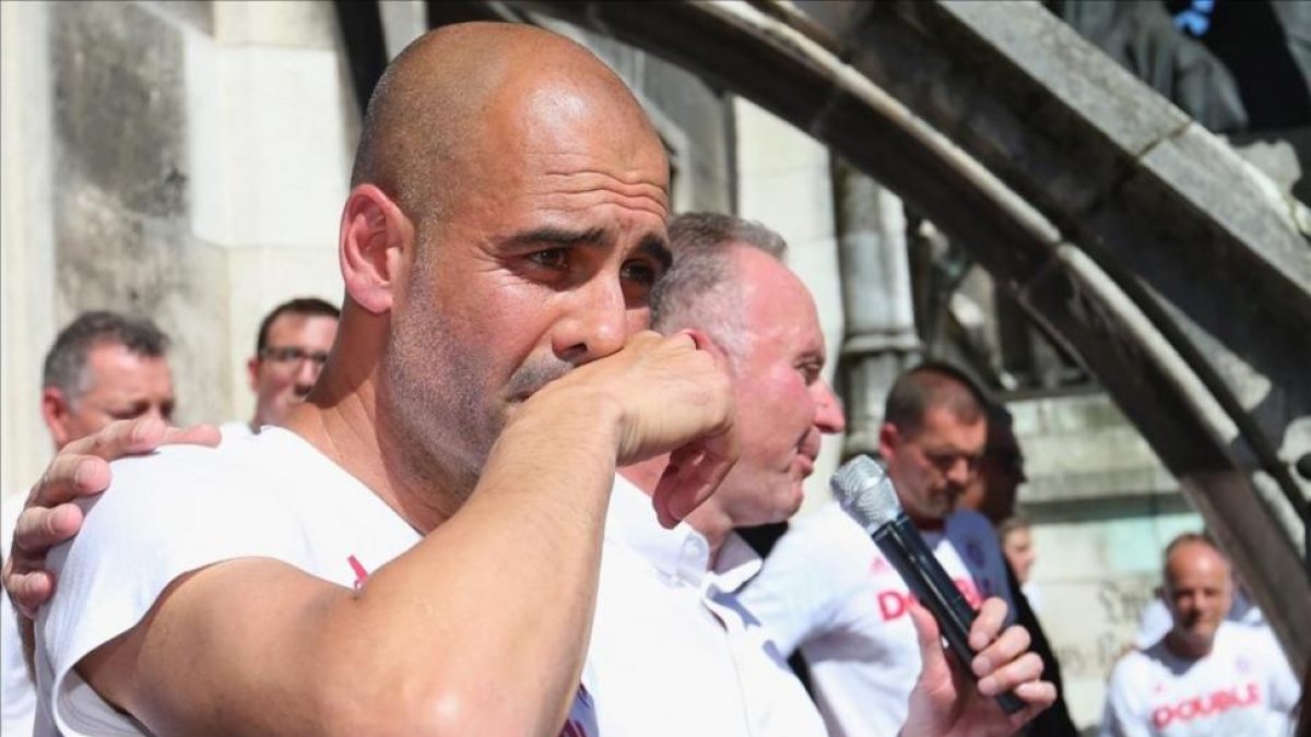 Guradiola, emocionado junto a Rummenigge, en la celebración del Bayern de este domingo.-EFE / ALEXANDER HASSENSTEIN