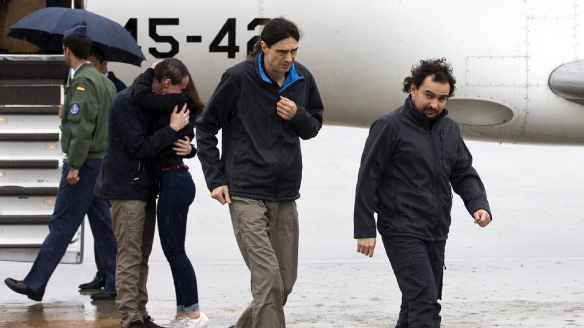 Los periodistas españoles Ángel Sastre (derecha), José Manuel López (centro) y Antonio Pampliega (abrazando a un familiar), a su llegada esta mañana a la Base Aérea de Torrejón de Ardoz, en Madrid.-EFE