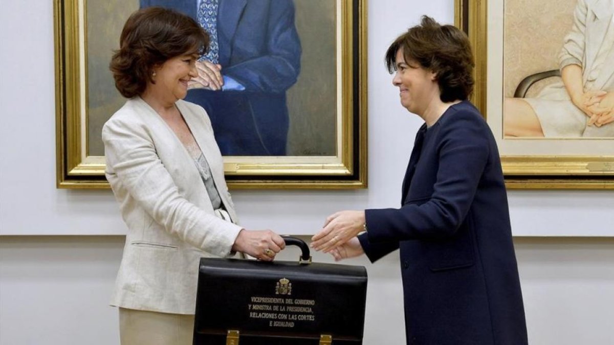 Carmen Calvo y Soraya Sáenz de Santamaría, durante el traspaso de poderes.-/ PERIODICO (EFE / LUCA PERGIOVANNI)