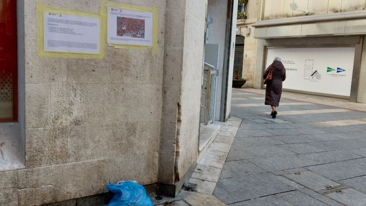Basura tirada en la calle San Carlos, a 200 metros del Ayuntamiento, bajo in cartel que avisa de los cambios en el sistema de recogida. L. G. L.