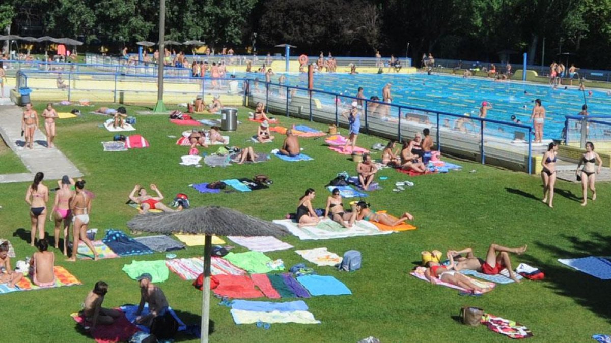 Varias personas disfrutan de las piscinas de El Plantío. ECB