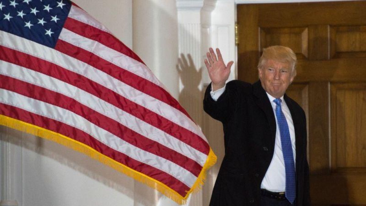 Trump saluda a los medios, en la entrada del club de golf que lleva su nombre, en Bedminster.-AFP / DON EMMERT