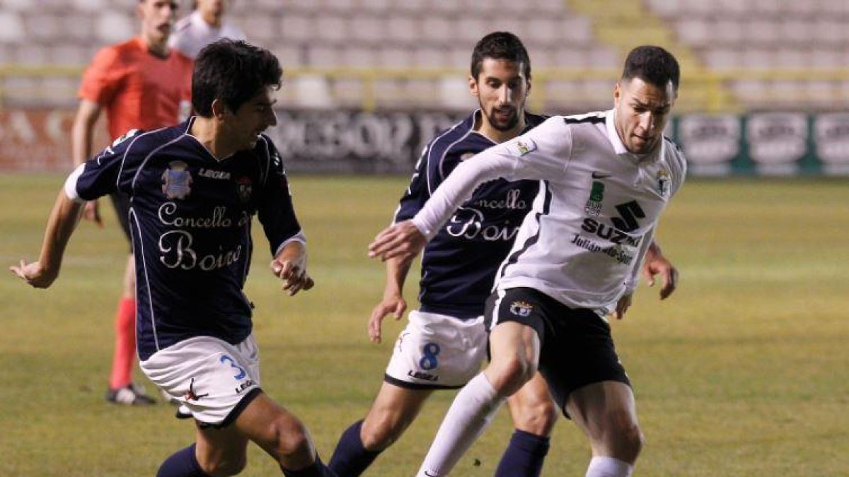 Armiche, que volverá a ser titular, protege el balón ante dos adversarios.-SANTI OTERO
