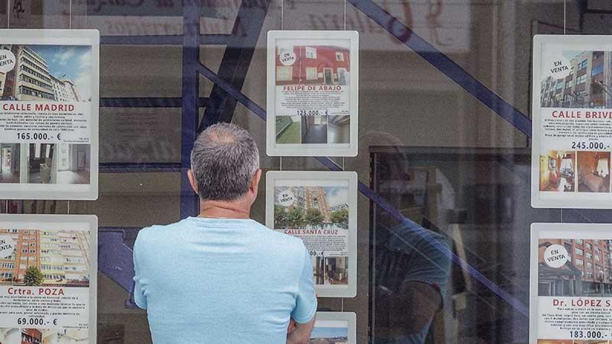Una persona observa los anuncios de una agencia inmobiliaria.-RAÚL G. OCHOA