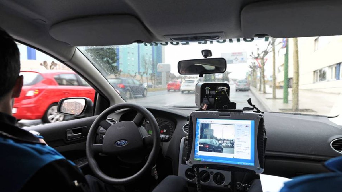 Dos agentes vigilan el dispositivo del radar móvil en una calle de la capital.-ISRAEL L. MURILLO