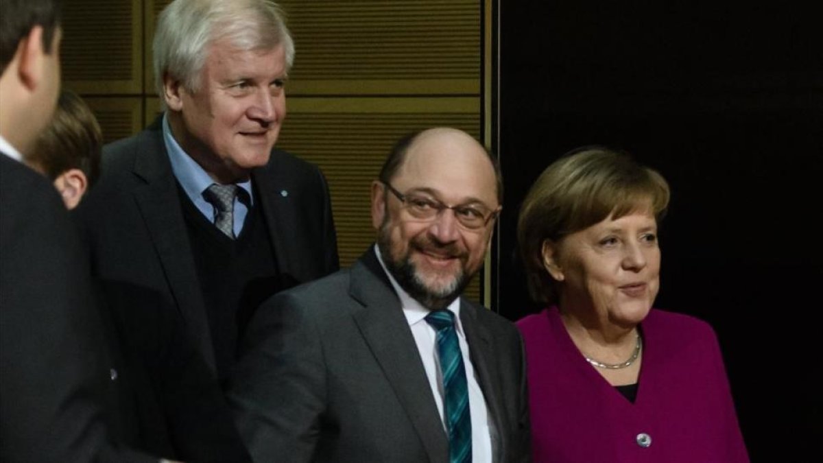 Merkel (derecha), junto a Schulz (centro) y Horst Seehofer, presidente de la CSU, durante la reunión en la sede del Partido Socialdemócrata (SPD) en Berlín, el 2 de febrero.-/ EFE / CLEMENS BILAN