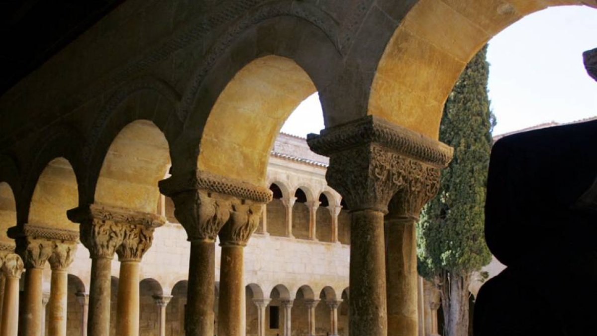 El claustro románico de la abadía, con su enhiesto ciprés, es uno de los símbolos de Santo Domingo de Silos.-ECB