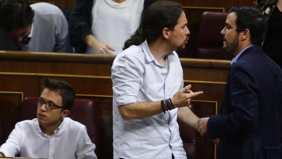 Iglesias conversa con Garzón, al lado de Errejón, en el debate de investidura de Rajoy.-AGUSTIN CATALAN