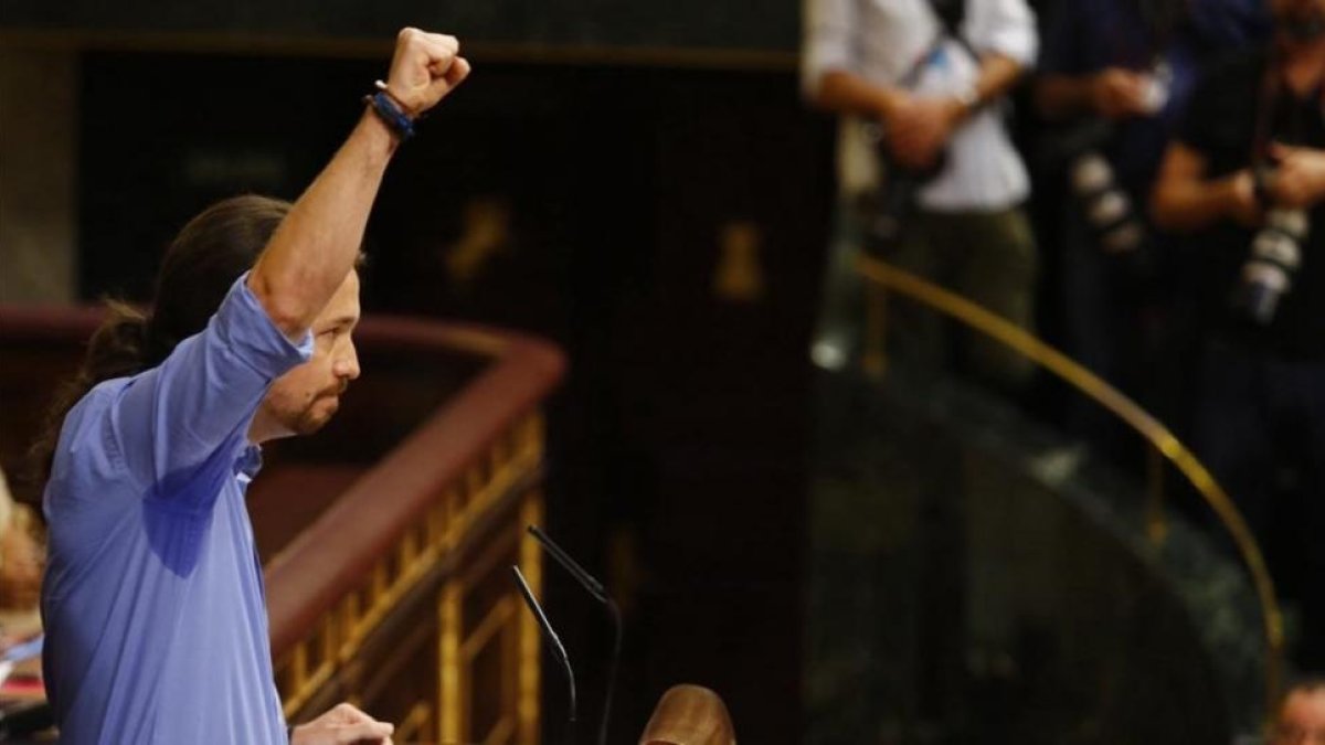 Pablo Iglesias alza el puño durante su intevención en el debate de investidura de Mariano Rajoy.-AGUSTÍN CATALÁN