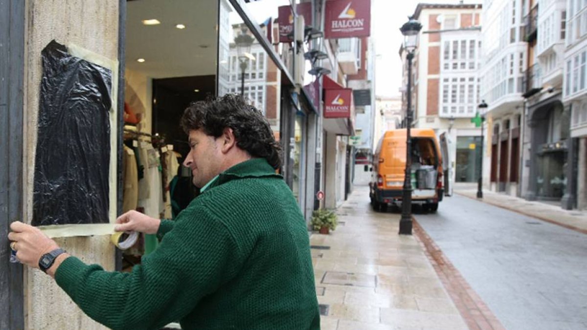 Un operario municipal limpiando una pintada de un comercio.-RAÚL G. OCHOA