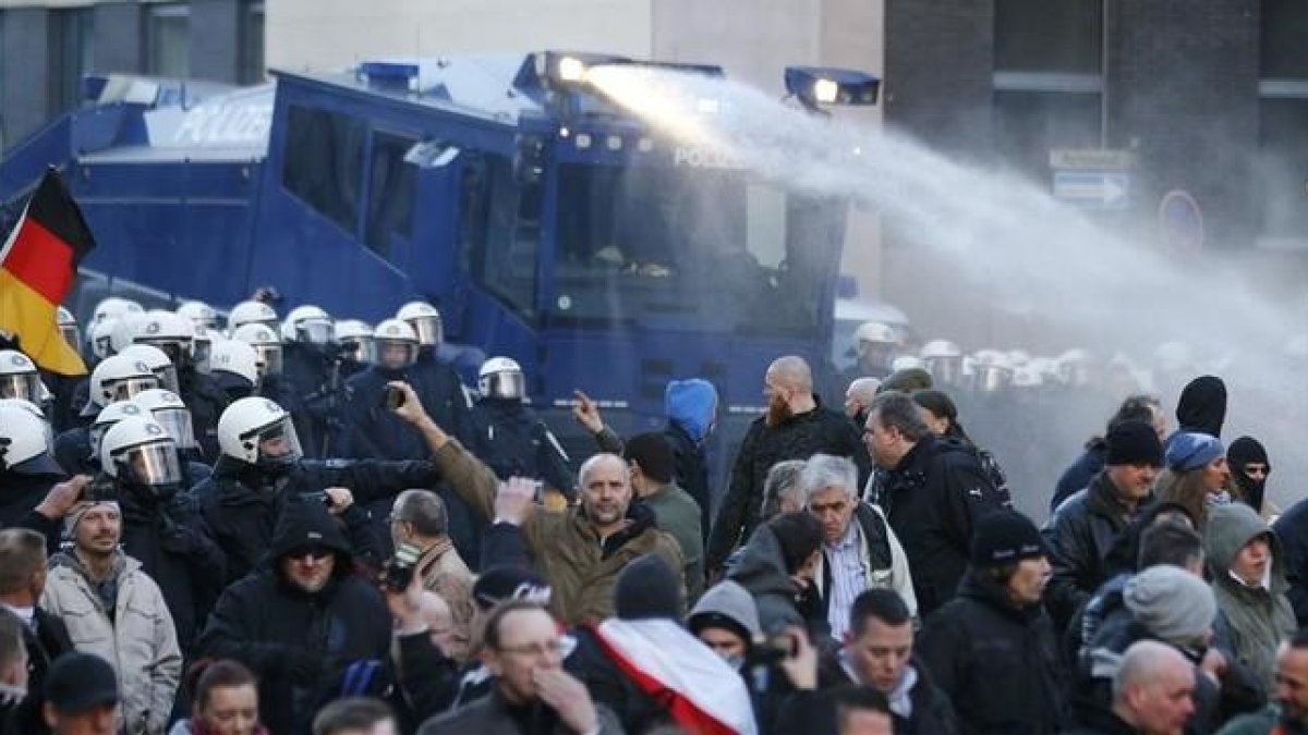 La policía dispara cañones de agua contra los manifestantes de Pegida, este sábado, en Colonia.-REUTERS / WOLFGANG RATTAY