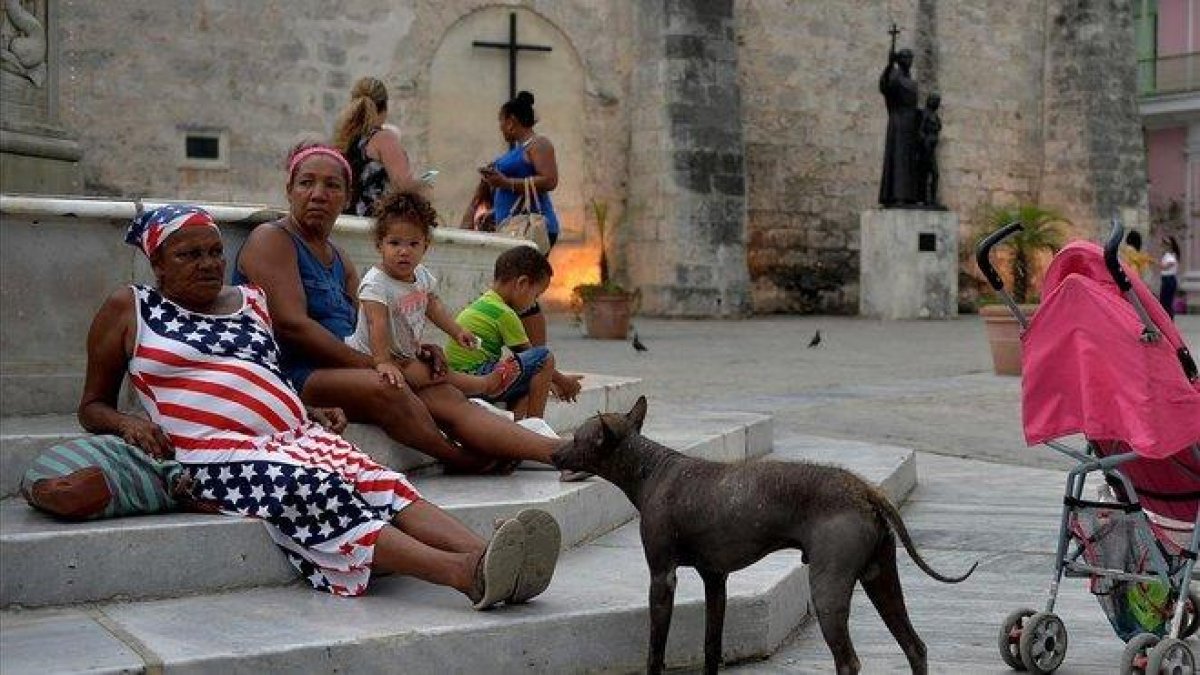 Unos turistas dan un paseo en un vehículo clásico utilizado como taxi en La Habana, el pasado 6 de mayo.-YAMIL LAGE (AFP)