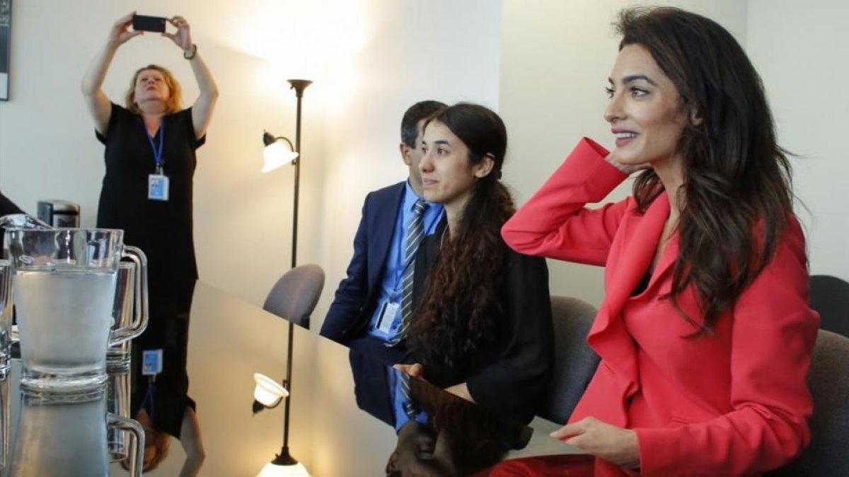 Amal Clooney (de rojo) junto a Nadia Murad, este lunes en Naciones Unidas, durante una entrevista con el ministro de asustos exteriores francés Jean-Marc Ayrault.-AFP / KENA BETANCUR
