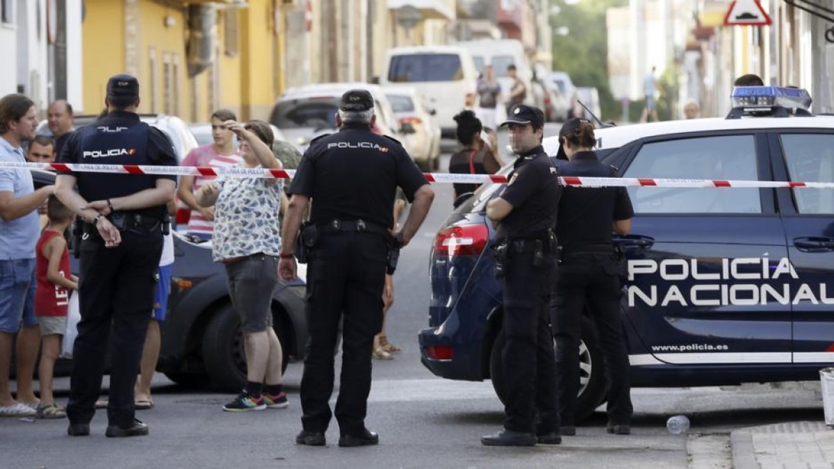 EFE / JOSÉ MANUEL VIDAL Agentes de policía y vecinos, frente al domicilio donde un hombre ha matado a su expareja, en Sevilla.-EFE