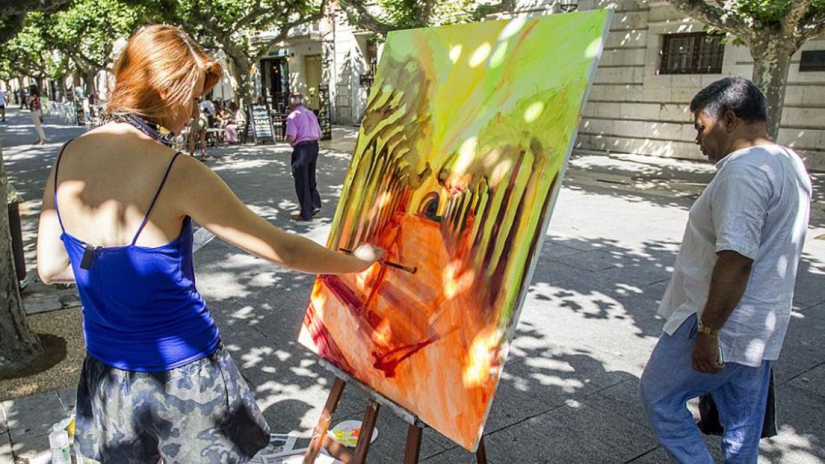 Una pintora plasma su visión del paseo del Espolón con el Arco de Santa María al fondo.-SANTI OTERO