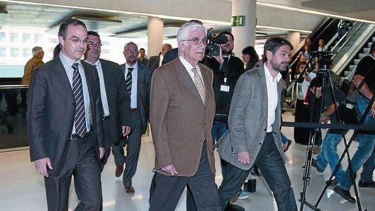 Daniel Osàcar, arropado por Jordi Turull y Oriol Pujol, a su llegada a la Ciutat de la Justícia en su citación como imputado por el 'caso Palau' en una foto de archivo.-JULIO CARBÓ