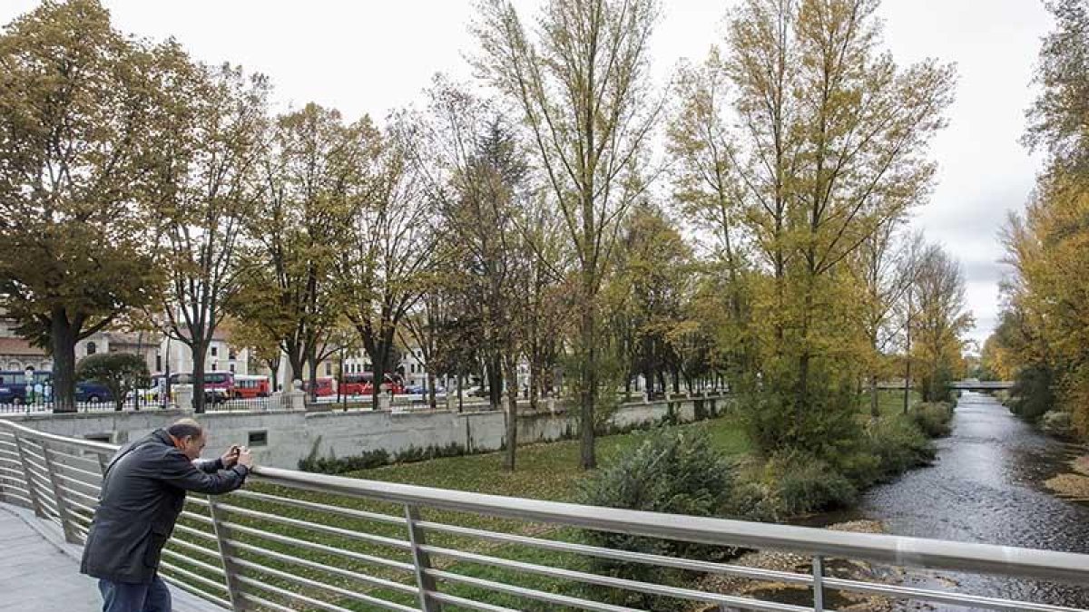Un hombre hace una foto al río Arlanzón.-SANTI OTERO