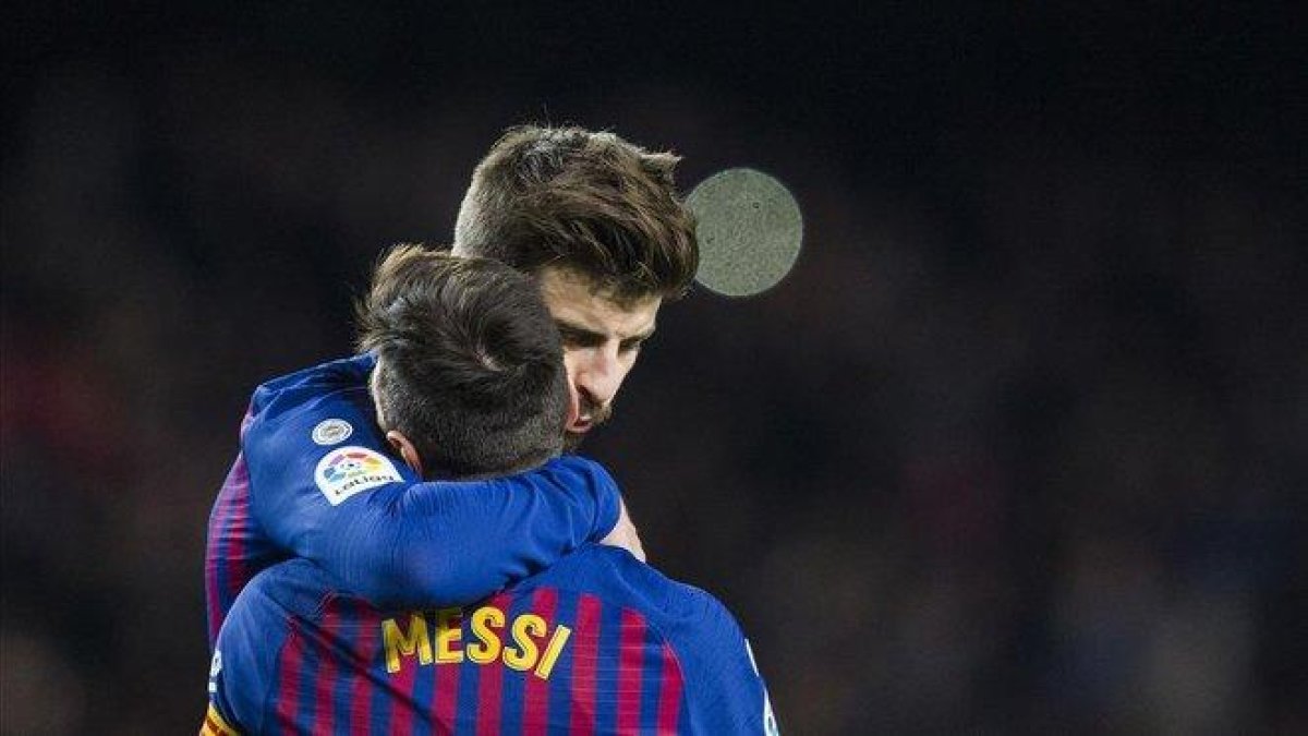 Gerard Piqué y Leo Messi se abrazan tras un gol.-