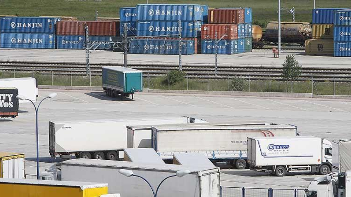 Camiones aparcados en el Centro de Transportes de Burgos y, al fondo, contenedores de mercancías en la playa de descarga.