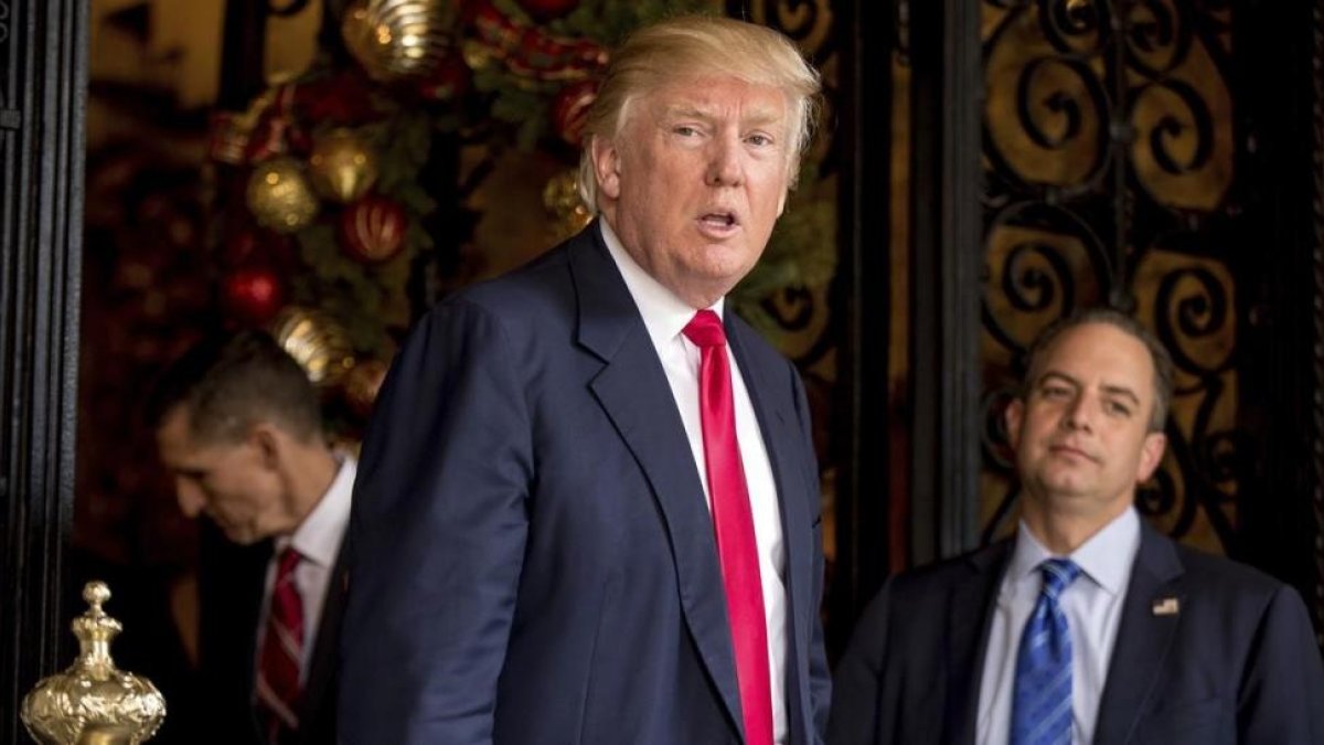 Trump (centro), acompañado por Priebus (derecha) y el consejero Michael Flynn, en Mar-a-Lago (Florida), el 21 de diciembre del 2016.-/ AP / ANDREW HARNIK