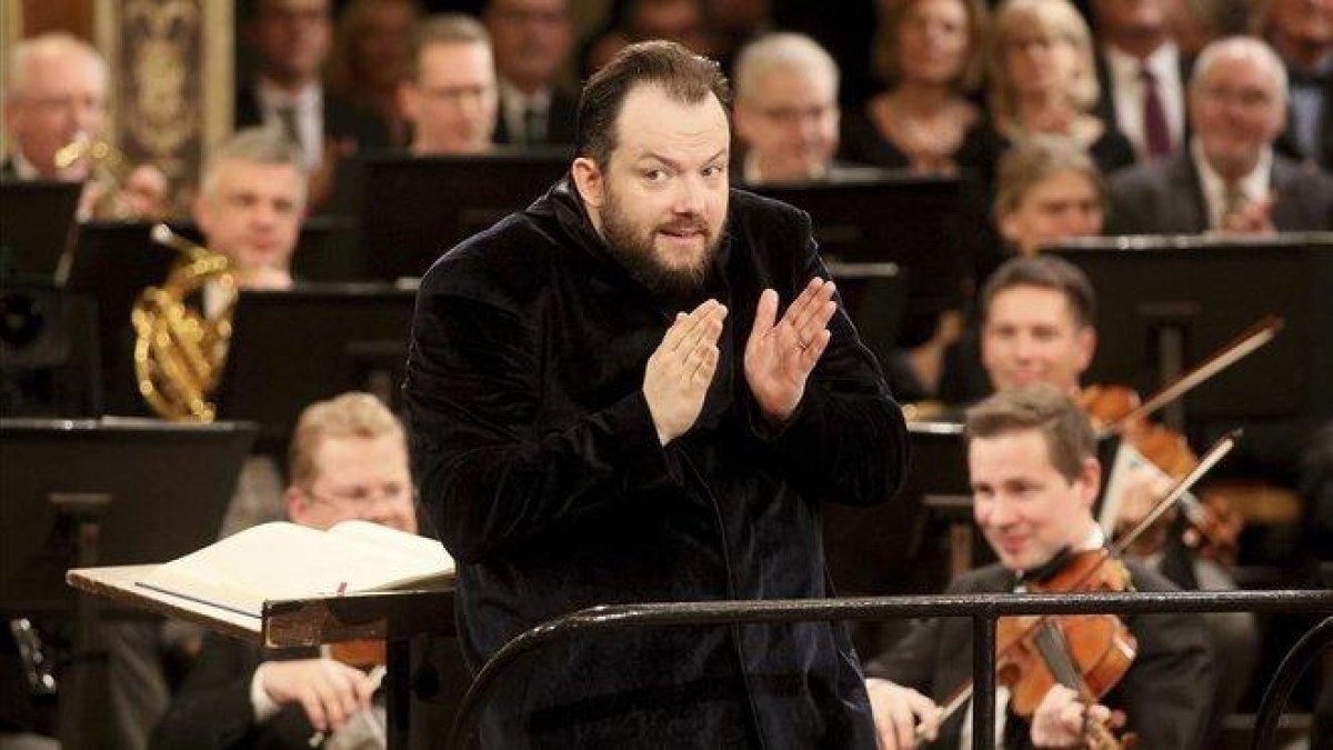 El director Andris Nelsons intenta moderar el volumen de los aplausos del público durante la Marcha Radetzky.-AP